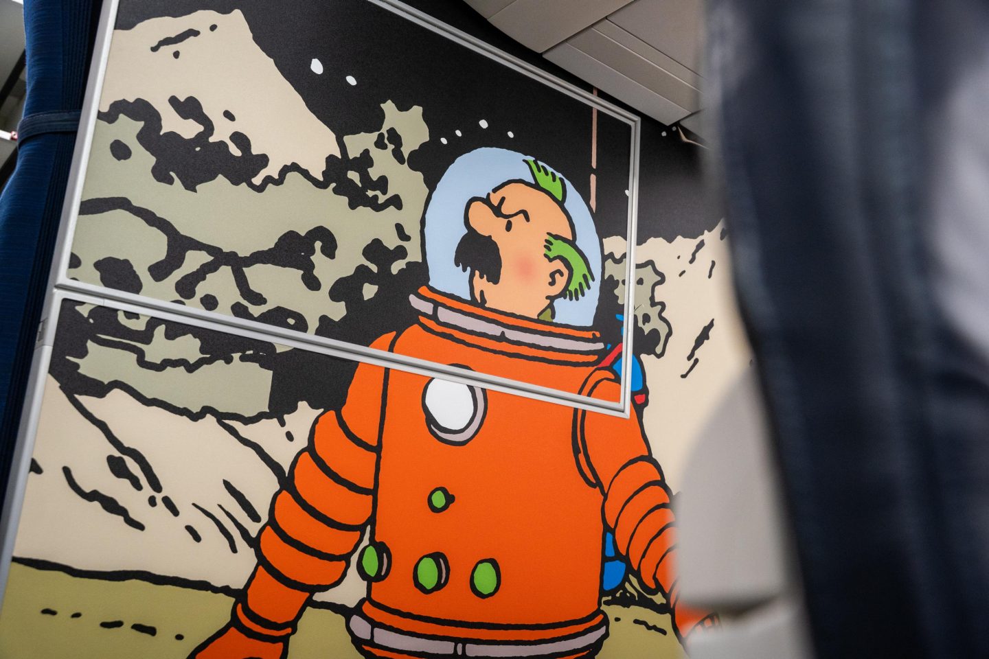 Captain Haddock from Tintin wearing an orange spacesuit on the moon.