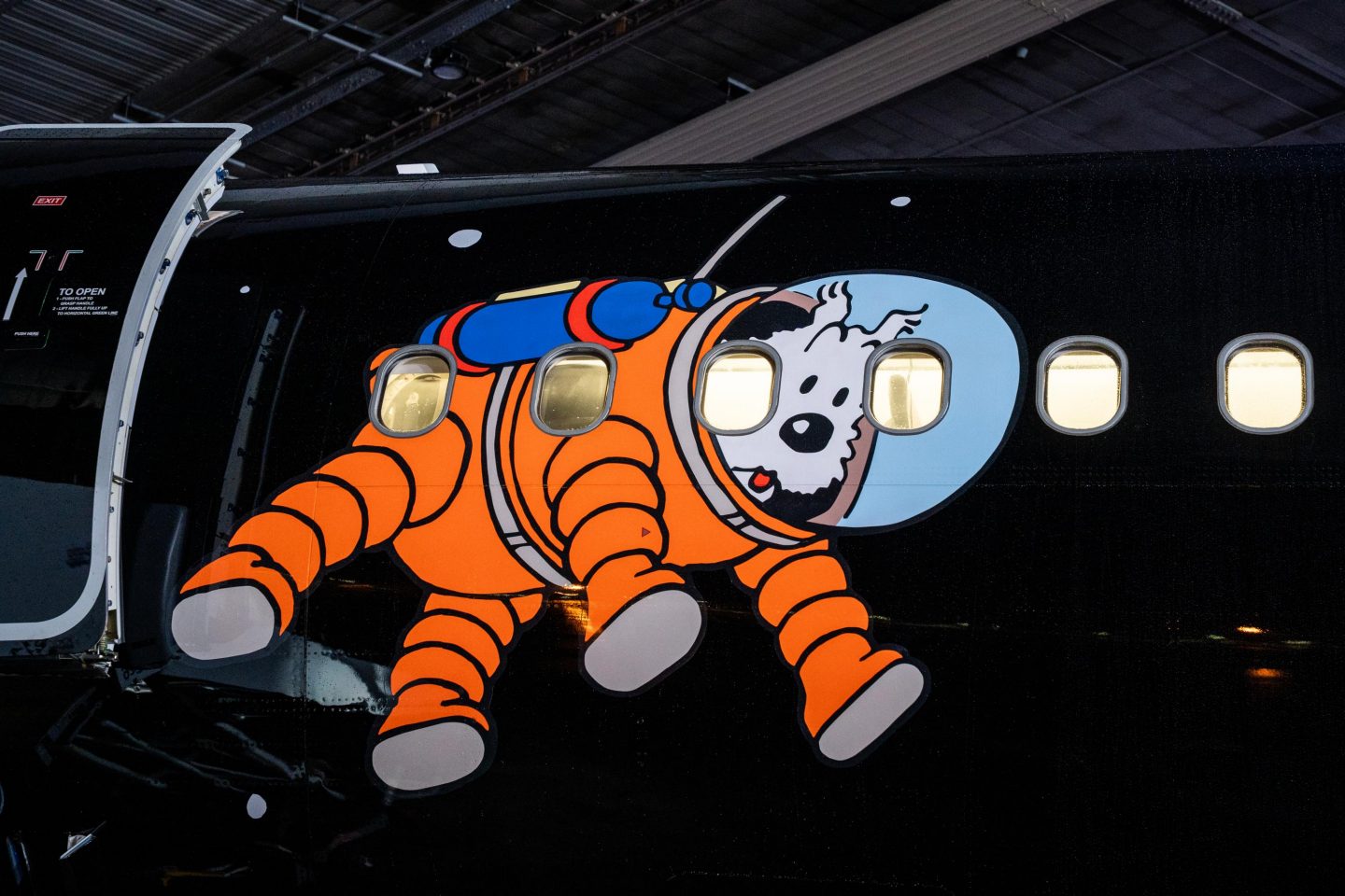 Airplane fuselage painted with Snowy in an orange spacesuit