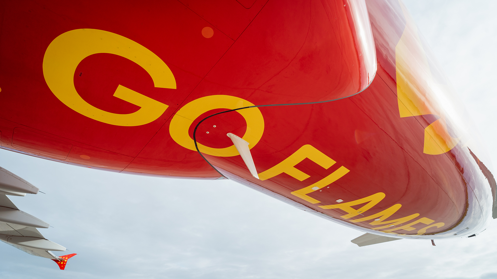Underside of red airplane fuselage with large yellow GO FLAMES text