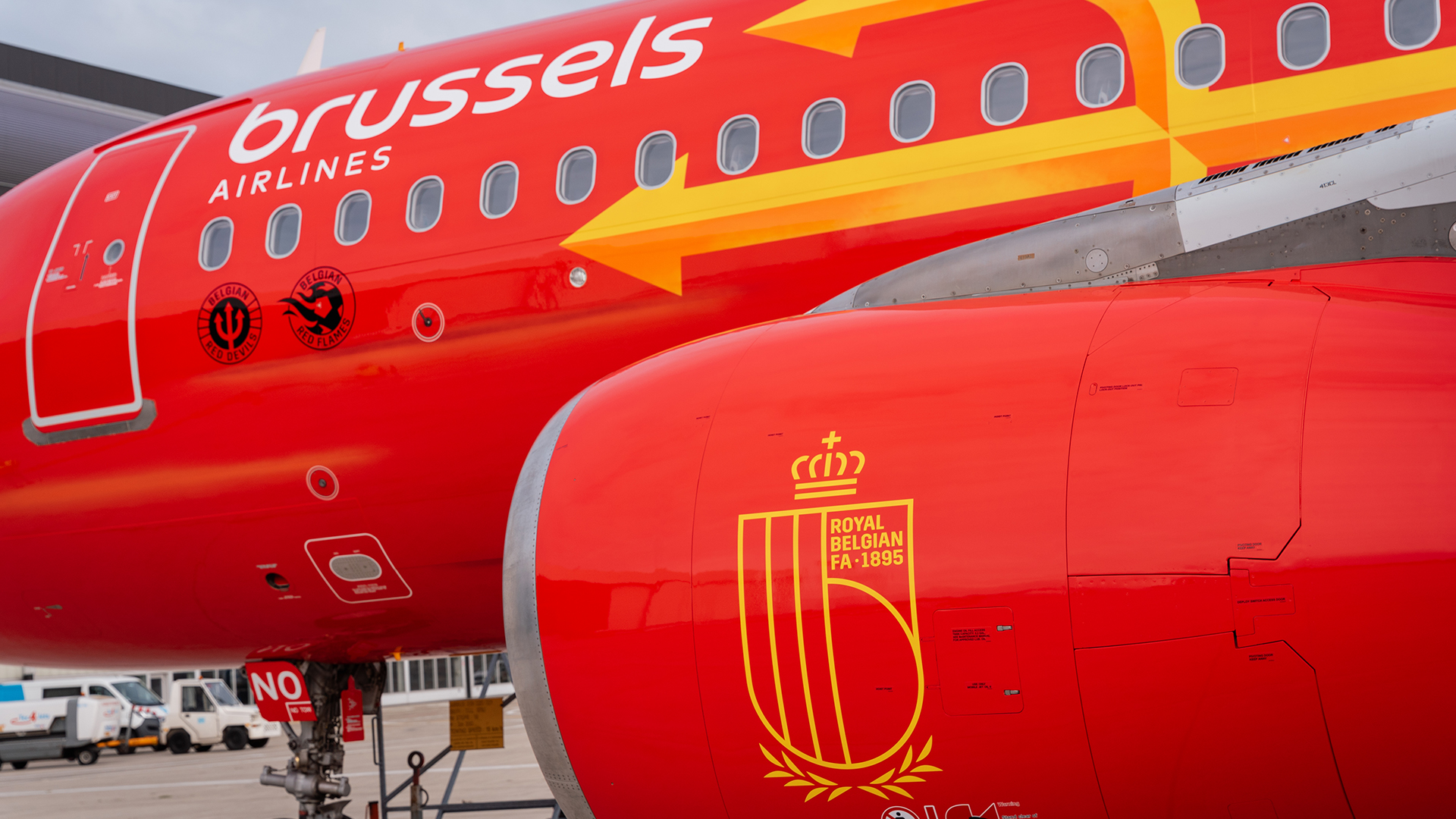 Close-up of a red airplane engine displaying the yellow Royal Belgian FA logo.