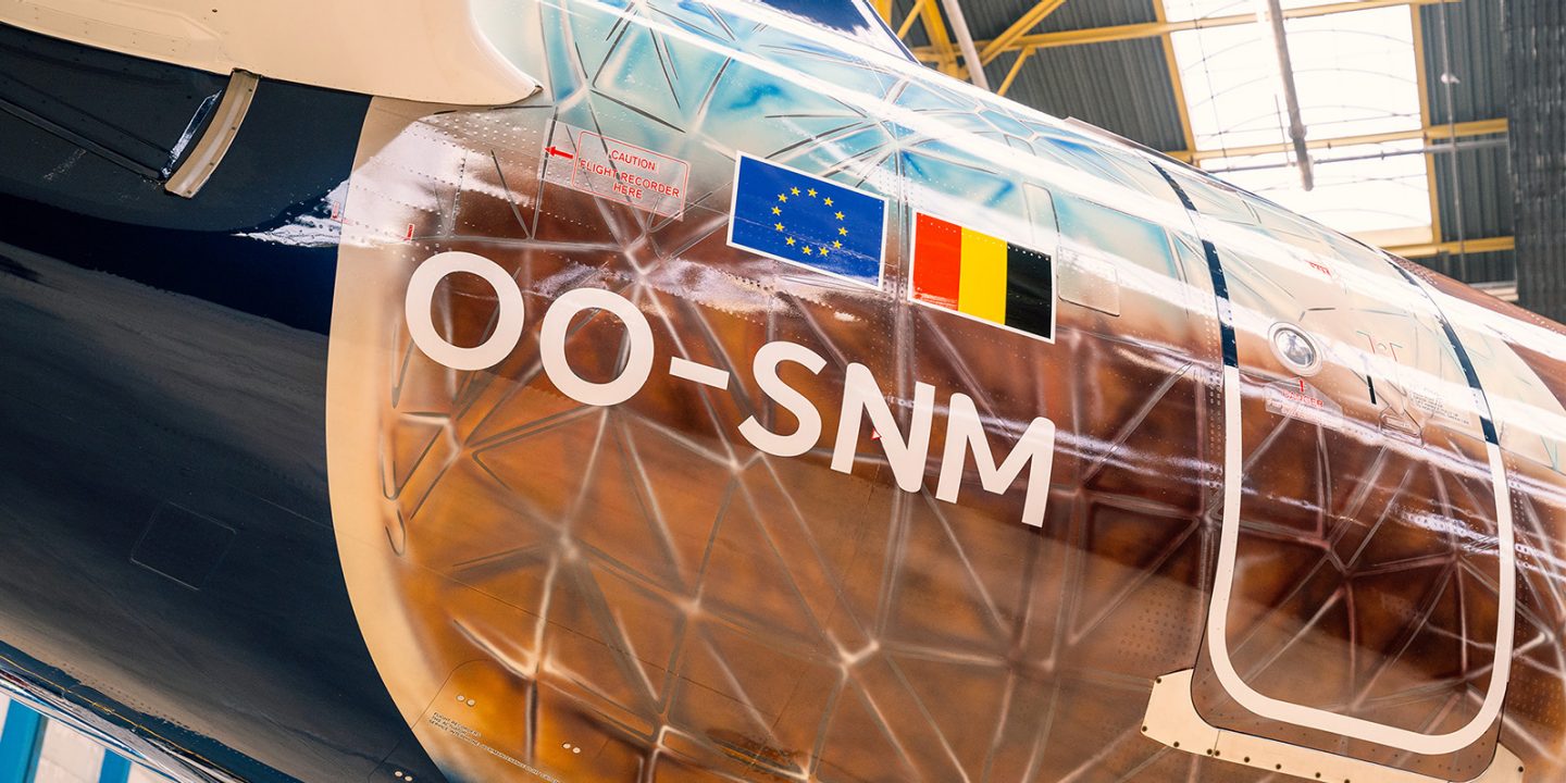 Close-up of an airplane fuselage displaying the registration OO-SNM.
