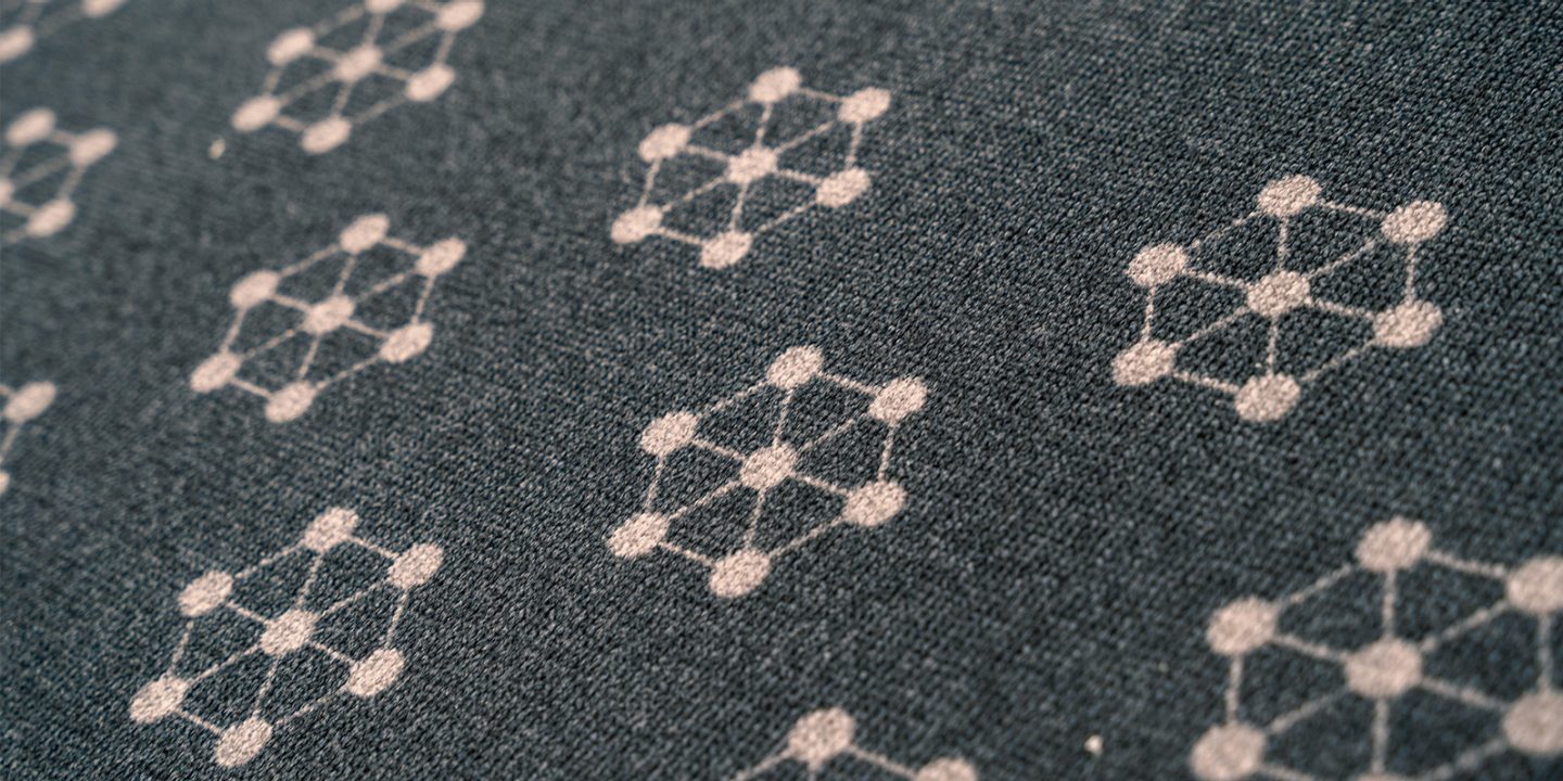 Dark grey fabric featuring a repeating Atomium pattern.