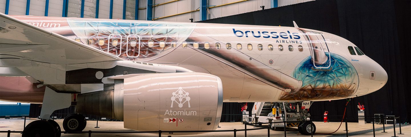 A Brussels Airlines airplane with a special Atomium paint design parked in a hangar.